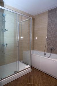 a bathroom with a shower and a bath tub at Hotel R in Sarajevo