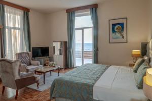 a hotel room with a bed and a balcony with the ocean at DOME Hotel & Casino at Central Kyrenia in Kyrenia