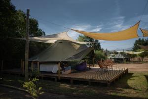 a tent with a table and chairs on a deck at Glamping, escapada en la naturaleza in San Clemente