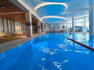 - une grande piscine d'eau bleue dans un bâtiment dans l'établissement Wunderbares Appartements mit Swimmingpoolbereich - Nemo Apartamenty Kolberg, à Kołobrzeg