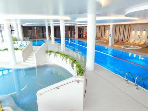 - une grande piscine dans un bâtiment dans l'établissement Wunderbares Appartements mit Swimmingpoolbereich - Nemo Apartamenty Kolberg, à Kołobrzeg