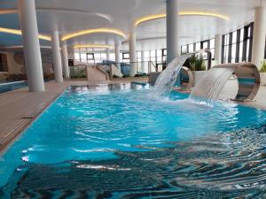 - une piscine avec toboggan dans un bâtiment dans l'établissement Wunderbares Appartements mit Swimmingpoolbereich - Nemo Apartamenty Kolberg, à Kołobrzeg