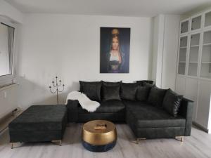 sala de estar con sofá negro y mesa en Romantik Ferienwohnung Bollenhut Superior en Lenzkirch