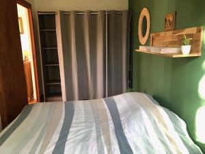 1 dormitorio con cama y pared verde en villa des pins, en Tallard