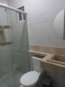 a bathroom with a toilet and a shower and a sink at Casa Temporada Atalaia in Luis Correia