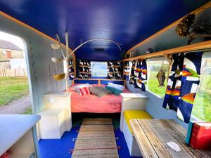 une chambre avec un lit à l'intérieur d'un bus dans l'établissement Camping Les Ronds Duval face aux îles anglo-normandes, à Les Moitiers-dʼAllonne