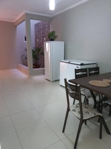 a kitchen with a table and a refrigerator at Casa Temporada Atalaia in Luis Correia +4 photos