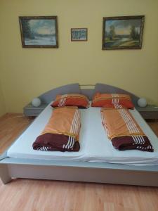uma cama com três almofadas num quarto em Schönes Ferienhaus mit Pool in ruhiger Lage em Balatonszentgyörgy