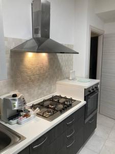 uma cozinha com uma placa de fogão e um lavatório em ADiNHOME Acicastello em Aci Castello