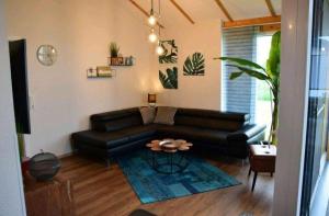 a living room with a black leather couch and a table at G7 Haus mit Blick ins Landschaftsschutzgebiet in Großwürden