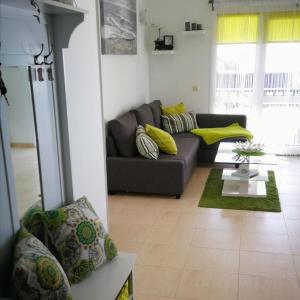 een woonkamer met een grijze bank en gele kussens bij Sich wie zu Hause fühlen in Playa Blanca