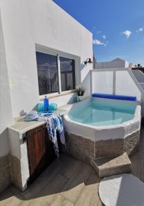 een hot tub aan de zijkant van een gebouw bij Sich wie zu Hause fühlen in Playa Blanca