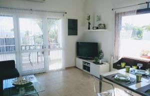 een woonkamer met een televisie en een tafel bij Sich wie zu Hause fühlen in Playa Blanca