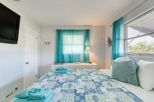 een slaapkamer met een bed en een raam met blauwe gordijnen bij Punta Gorda Family Home about 8 Mi to Downtown! in Punta Gorda