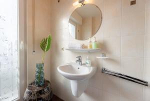 La salle de bains est pourvue d'un lavabo et d'un miroir. dans l'établissement Cozy 1BR Apartment in Esch-sur-Alzette, à Esch-sur-Alzette