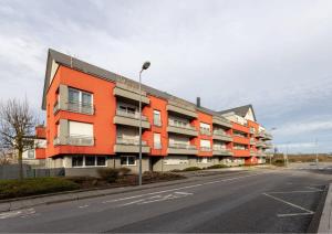 un bâtiment orange sur le côté d'une rue dans l'établissement Cozy 1BR Apartment in Esch-sur-Alzette, à Esch-sur-Alzette