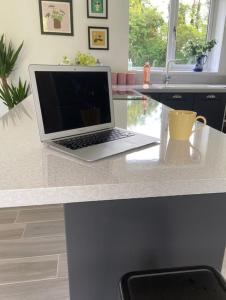 a laptop computer sitting on a counter in a kitchen at Garden Room Dormston in Kington