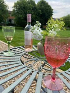 een tafel met twee glazen en een fles wijn bij Garden Room Dormston in Kington