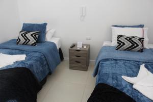 a bedroom with two beds and a night stand at Hostal El Valle in Illapel