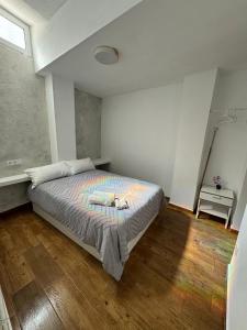 una camera con un grande letto e pavimenti in legno di Apartamento Completo en Alcoy ad Alcoy