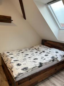 Ce lit se trouve dans un dortoir doté d'une fenêtre. dans l'établissement Zlonice - Ubytování 1kk, à Slaný
