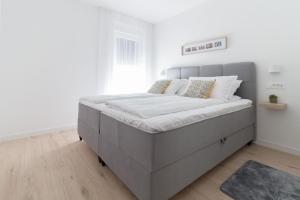 een groot bed in een slaapkamer met witte muren bij Ferienwohnung für 5 Personen ca 70 qm in Nin, Dalmatien Norddalmatien - b61874 in Nin