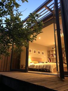 Schlafzimmer mit einem Bett und einem großen Glasfenster in der Unterkunft La cabane du bonheur in Aix-les-Bains