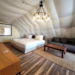 a bedroom with a bed and a couch in a tent at Desert Breeze in Al Ḩamrānīyah