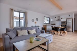 a living room with a couch and a table at Villa avec Jacuzzi et Clim à Marsilly in Lagord
