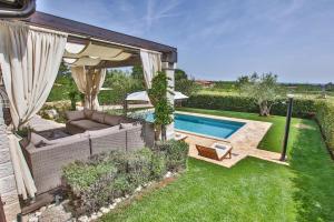 a backyard with a swimming pool and a patio at Villa Elizabet bei Porec mit Pool in Babići