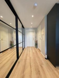 an empty hallway with wood floors and glass walls at Scandpoint Apartment Exquisite & Homely Flat in Lillestrom Center Oslo with Parking in Lillestrøm