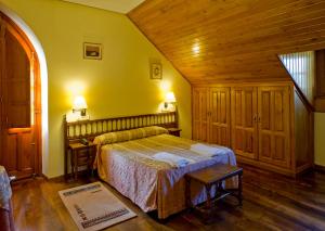 1 dormitorio con cama y techo de madera en Hotel Restaurante La Casilla, en Cangas del Narcea