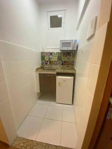 a small white kitchen with a sink and a counter at Fantástico AP no Centro do RJ! Ótima localização! in Rio de Janeiro