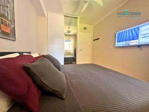 1 dormitorio con 1 cama y TV en la pared en Dos Torres Chill out, en Zaragoza