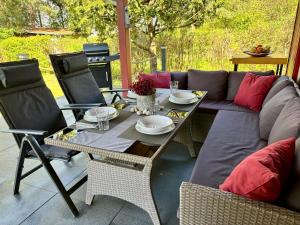 a patio with a couch and a table and chairs at Bungalow-Jessern Ferienhaus im Grünen mit Seeblick in Jessern