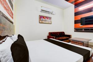 Hānsi的住宿－OYO Hotel Divine，配有一张床和一把椅子的酒店客房