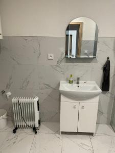 een witte badkamer met een wastafel en een spiegel bij Ubytovanie u Aničky 