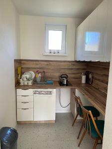 a kitchen with white cabinets and a sink and a window at Ubytovanie u Aničky 