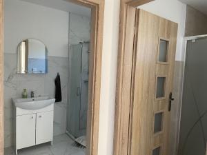 a bathroom with a shower and a sink and a mirror at Ubytovanie u Aničky 