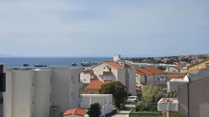 Eine Stadt mit Gebäuden und dem Meer im Hintergrund in der Unterkunft THREE FLOOR Deluxe Pool Apartments in Novalja