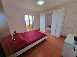 a bedroom with a bed with a red blanket at Case Vacanze Matteotti di Scilla in Scilla