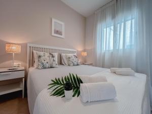 a bedroom with a white bed with a plant on it at Papaya Apartments Boa Vista in Sal Rei +62 photos