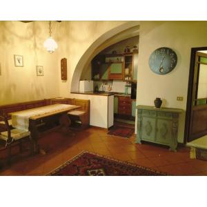 een keuken met een tafel en een klok aan de muur bij Residenza Fabroni in Montepulciano