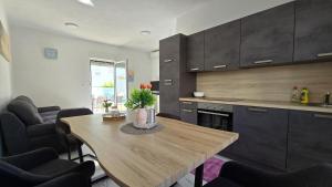 eine Küche mit einem Holztisch und Stühlen in der Unterkunft THREE FLOOR Deluxe Pool Apartments in Novalja + 34 Fotos