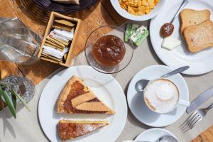 Pie' d'Ulivo في Bosco: طاولة مع أطباق من الطعام وكوب من القهوة
