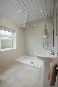 a white bathroom with a tub and a sink at Arnside - Spacious 10-Bedroom Seaside Cottage in Blackpool