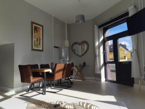 sala de estar con mesa, sillas y ventana en Haven Apartment, en Cork