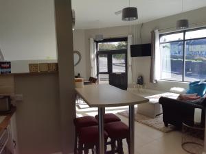 uma cozinha e sala de estar com mesa e cadeiras em Haven Apartment em Cork