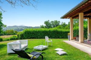 um jardim com cadeiras, um sofá e um gazebo em Villa Colle em Acqualagna