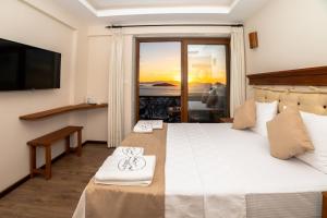 a bedroom with a bed with a view of the ocean at west coast boutique hotel in Bodrum City